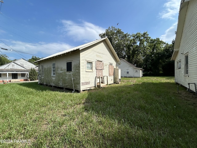 view of side of home with a yard