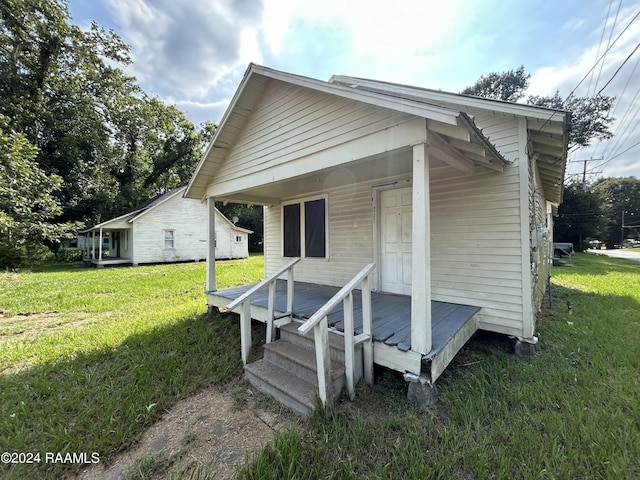 exterior space with a porch and a lawn