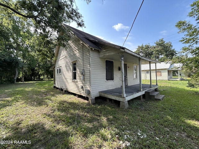 exterior space featuring covered porch and a yard