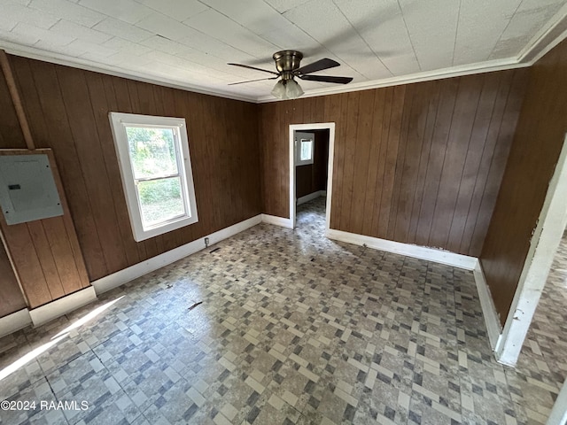 empty room featuring electric panel and wooden walls