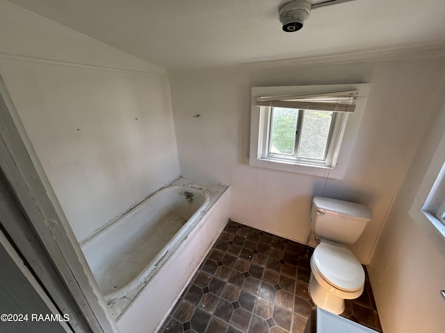 bathroom with toilet, a garden tub, and vaulted ceiling