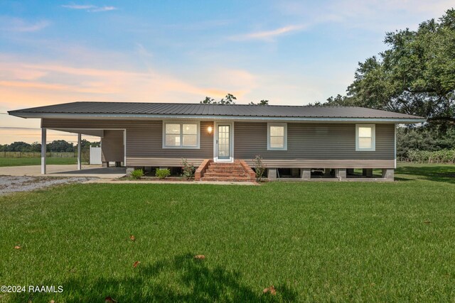 view of front of house featuring a carport and a lawn