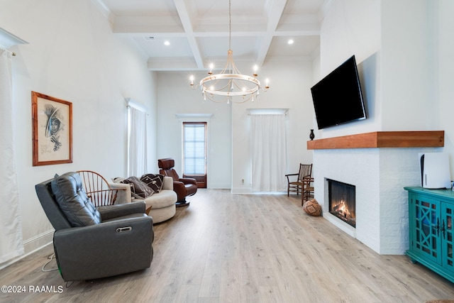 living room with a high ceiling, light wood-type flooring, beam ceiling, a chandelier, and coffered ceiling