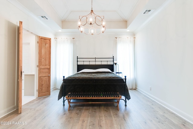 bedroom featuring multiple windows, a raised ceiling, and hardwood / wood-style floors