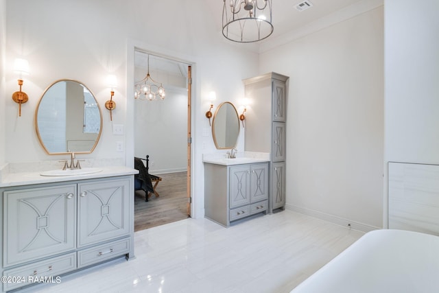 bathroom featuring hardwood / wood-style floors, an inviting chandelier, vanity, a bathtub, and crown molding