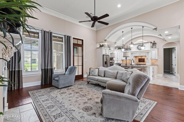 living room featuring ceiling fan, light hardwood / wood-style flooring, crown molding, and lofted ceiling