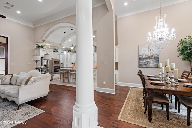 dining area featuring ornamental molding, dark hardwood / wood-style flooring, decorative columns, and a towering ceiling