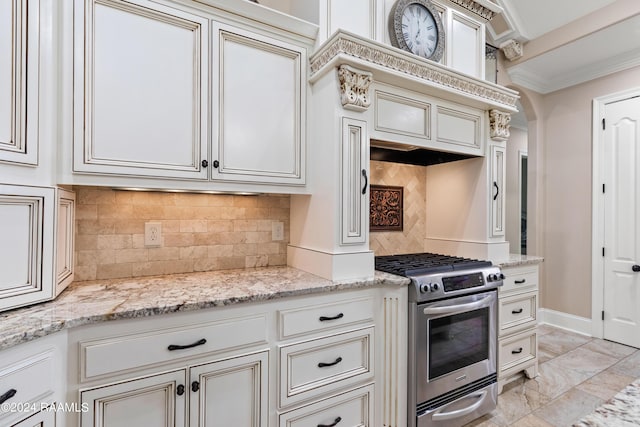 kitchen featuring light stone counters, crown molding, tasteful backsplash, gas range, and baseboards