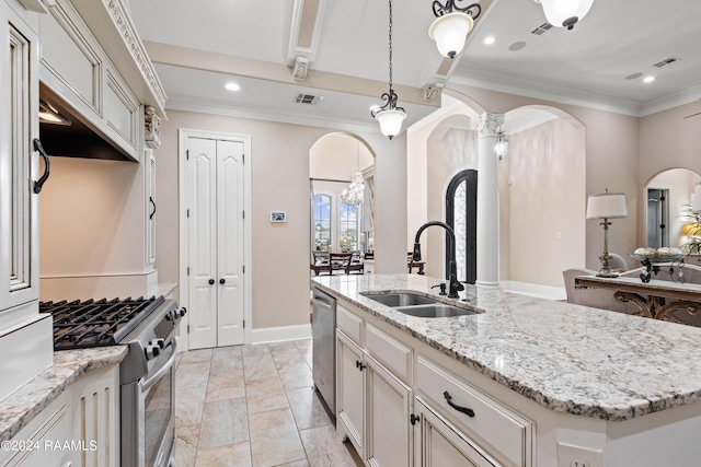 kitchen with light stone counters, arched walkways, a center island with sink, appliances with stainless steel finishes, and a sink