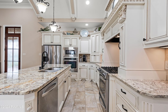 kitchen featuring light stone counters, a kitchen island with sink, stainless steel appliances, a sink, and decorative light fixtures