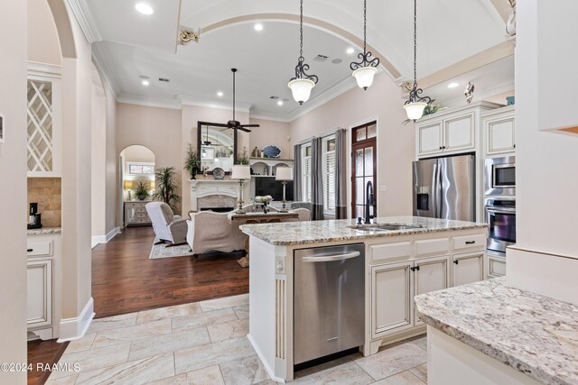 kitchen with appliances with stainless steel finishes, light hardwood / wood-style flooring, ornamental molding, and sink