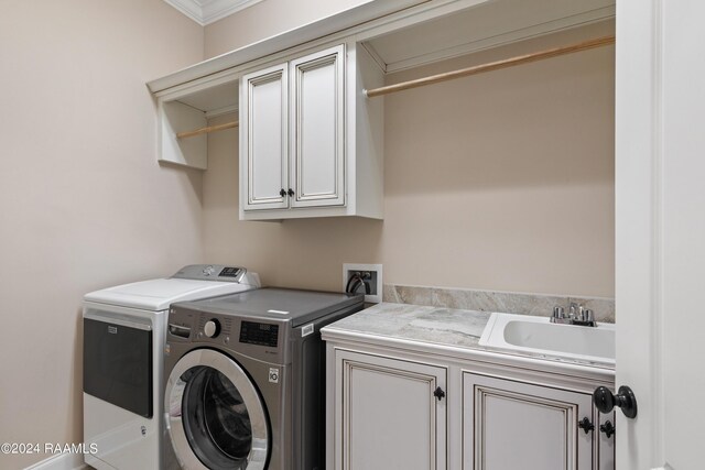 washroom featuring sink, crown molding, washer and clothes dryer, and cabinets