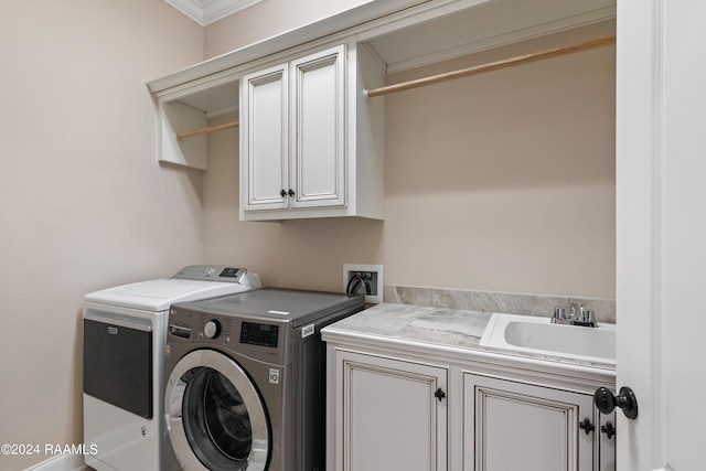 laundry area with cabinet space, separate washer and dryer, and a sink