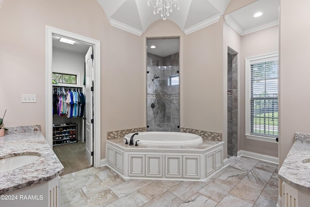 bathroom featuring a tile shower, a spacious closet, a sink, and baseboards