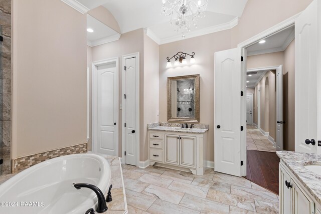 bathroom with tile patterned flooring, a tub to relax in, vanity, and ornamental molding