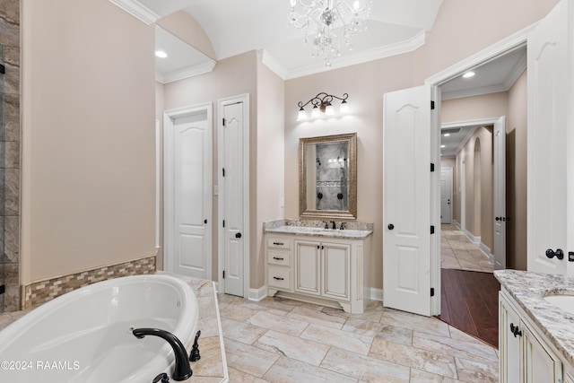 bathroom with a garden tub, ornamental molding, two vanities, and a sink