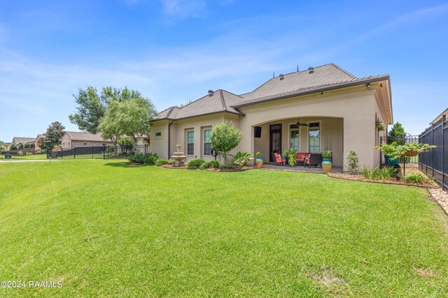 back of property featuring a patio area and a lawn