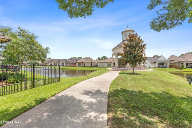 view of community featuring a water view and a yard