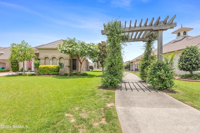 view of front facade featuring a front lawn, a pergola, and stucco siding