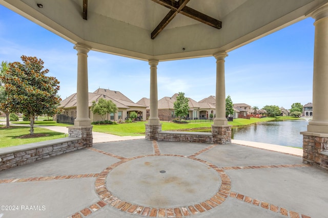 view of patio / terrace featuring a residential view, a water view, and ceiling fan