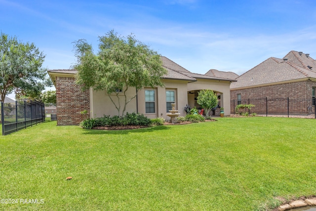 view of front of home with fence, a front lawn, and stucco siding