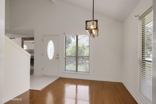 foyer with hardwood / wood-style floors and vaulted ceiling