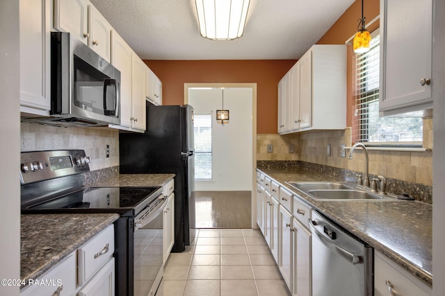 kitchen featuring decorative light fixtures, light hardwood / wood-style floors, stainless steel appliances, sink, and white cabinets