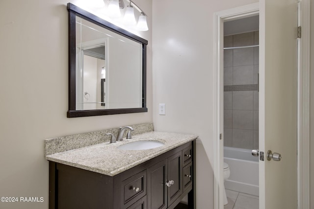 full bathroom featuring tiled shower / bath, vanity, toilet, and tile patterned floors