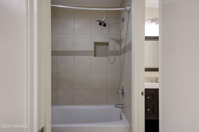 bathroom with tiled shower / bath and vanity