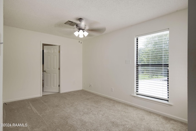 carpeted spare room with a textured ceiling and ceiling fan