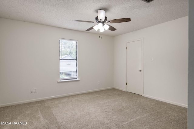 carpeted spare room with a textured ceiling and ceiling fan