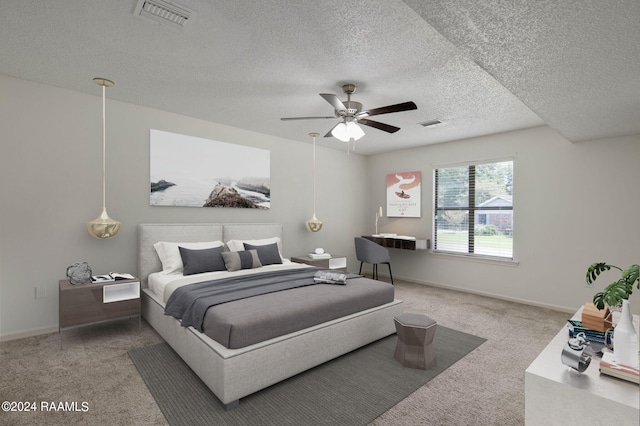 carpeted bedroom with a textured ceiling and ceiling fan