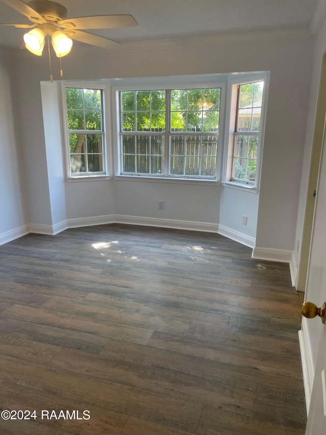 unfurnished room featuring ceiling fan, dark hardwood / wood-style flooring, and crown molding