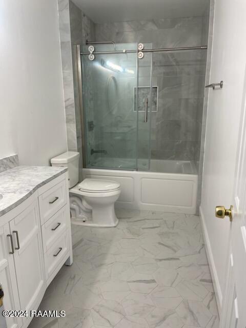 full bathroom featuring enclosed tub / shower combo, toilet, vanity, and tile patterned floors