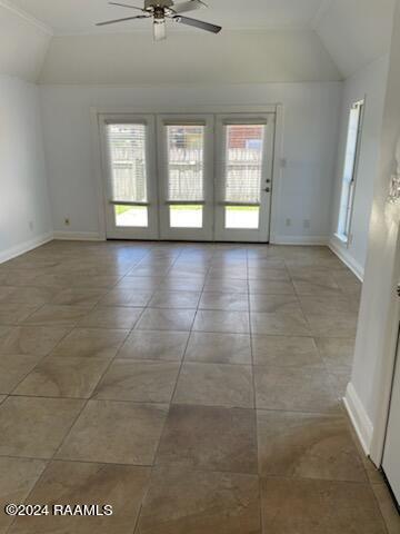 unfurnished room with tile patterned floors, french doors, lofted ceiling, and ceiling fan