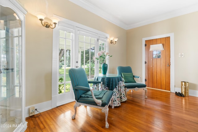 living area with baseboards, wood finished floors, ornamental molding, and french doors