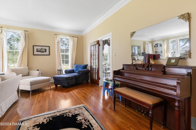 living area featuring wood finished floors, crown molding, and a wealth of natural light