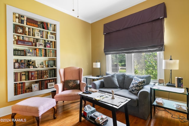 living area featuring wood finished floors and ornamental molding