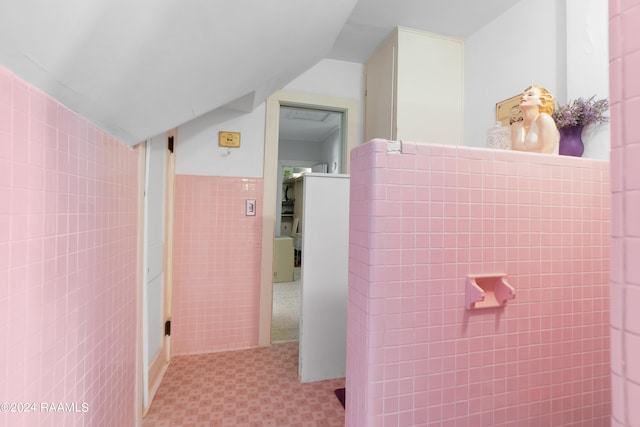 bathroom featuring tile walls, lofted ceiling, and tile patterned floors