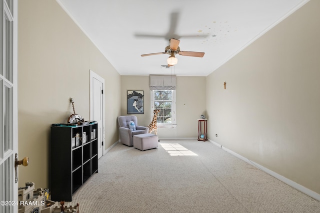 living area featuring baseboards, carpet floors, ornamental molding, and a ceiling fan