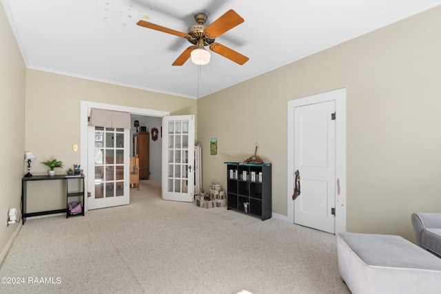 living area with carpet floors, french doors, a ceiling fan, baseboards, and ornamental molding