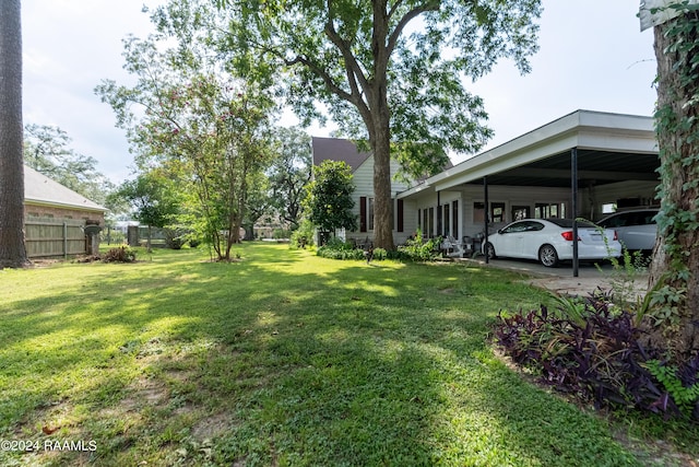 view of yard with an attached carport and fence