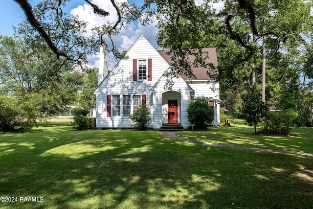 view of front of house featuring a chimney, a front lawn, and entry steps