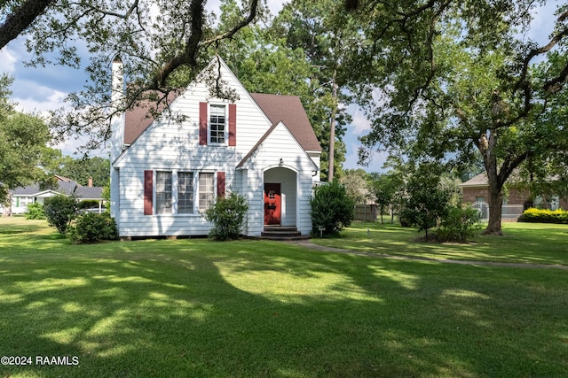 view of front of home with a front yard and a chimney