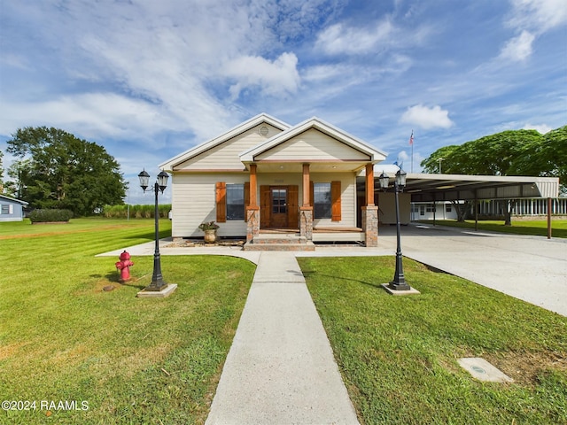 view of front of property featuring a carport, a front lawn, a porch, and driveway