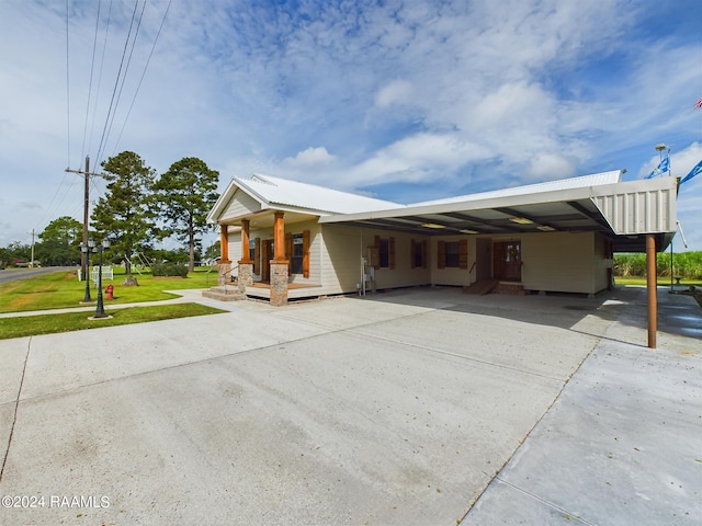 exterior space featuring driveway, a front lawn, and an attached carport