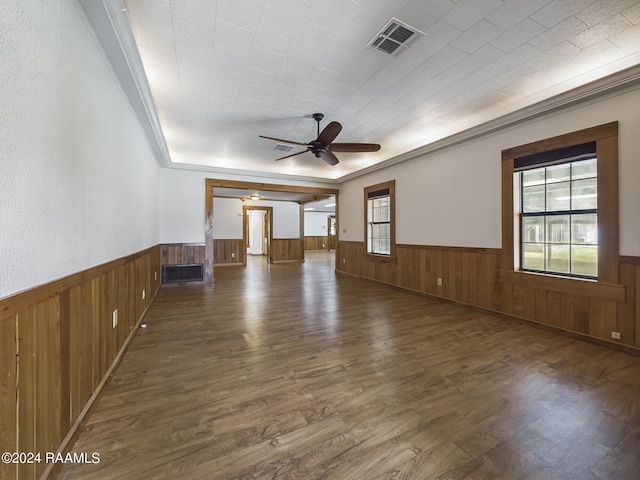 unfurnished living room with plenty of natural light, wainscoting, and visible vents