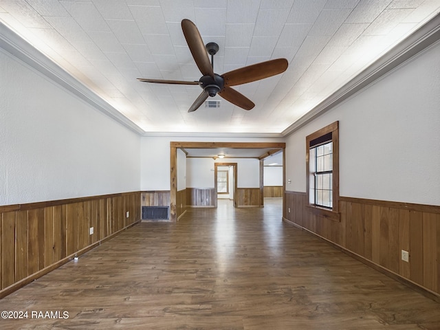 unfurnished room featuring a ceiling fan, a wainscoted wall, wood walls, and wood finished floors