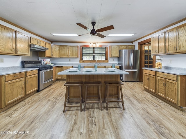 kitchen with ornamental molding, appliances with stainless steel finishes, light wood-type flooring, and a breakfast bar