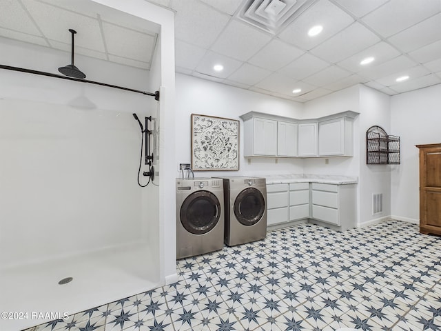 washroom featuring light floors, independent washer and dryer, cabinet space, and visible vents